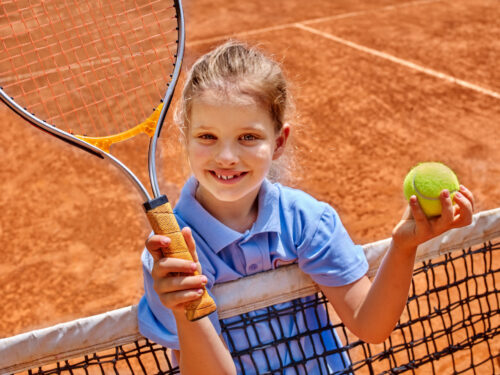 dziewczynka trzyma rakietę tenisową i piłkę, wysiłek fizyczny i alergia, wysiłek fizyczny a alergia
