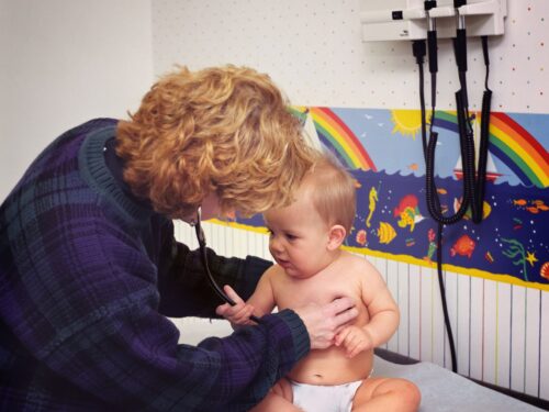 lekarz osłuchuje małe dziecko, alergia u dzieci