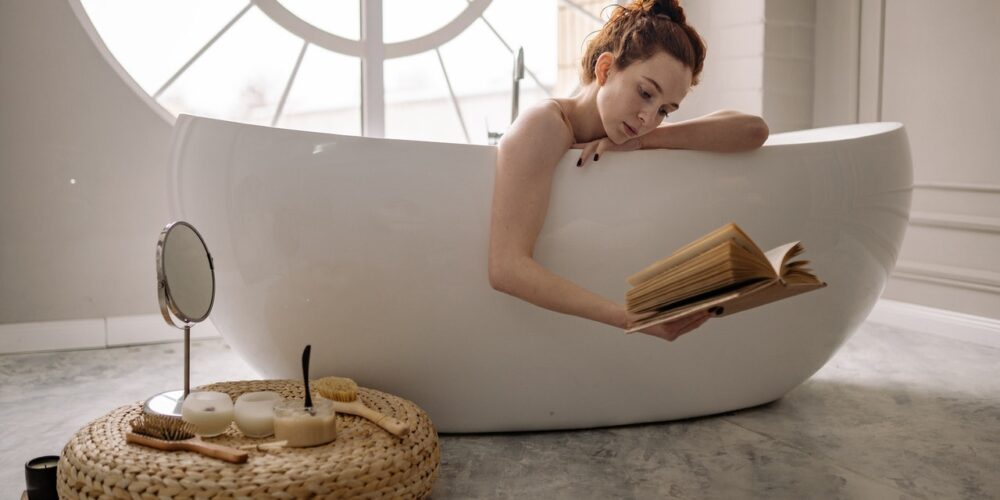 kobieta w wannie czyta książkę