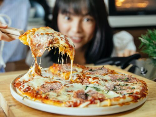 Pizza z ciągnącym serem, w tle kobieta, alfa‑laktoalbumina
