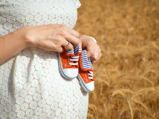 kobieta w ciąży, trzyma buciki, leki na alergię