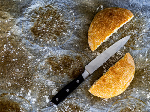 cut bread with knife on used baking paper and flour, cooking and
