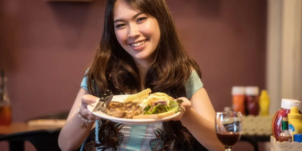 kobieta trzyma w rękach posiłek na białym talerzu
