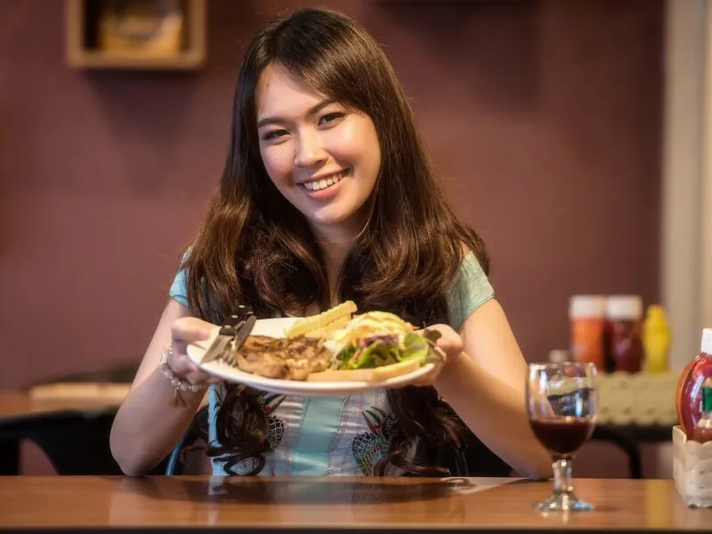 kobieta trzyma w rękach posiłek na białym talerzu